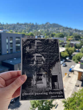 a postcard of the cover of ghosts passing through by Janet Dale. The cover features a black and white photo of an old hospital with vines covering most of the exterior. 